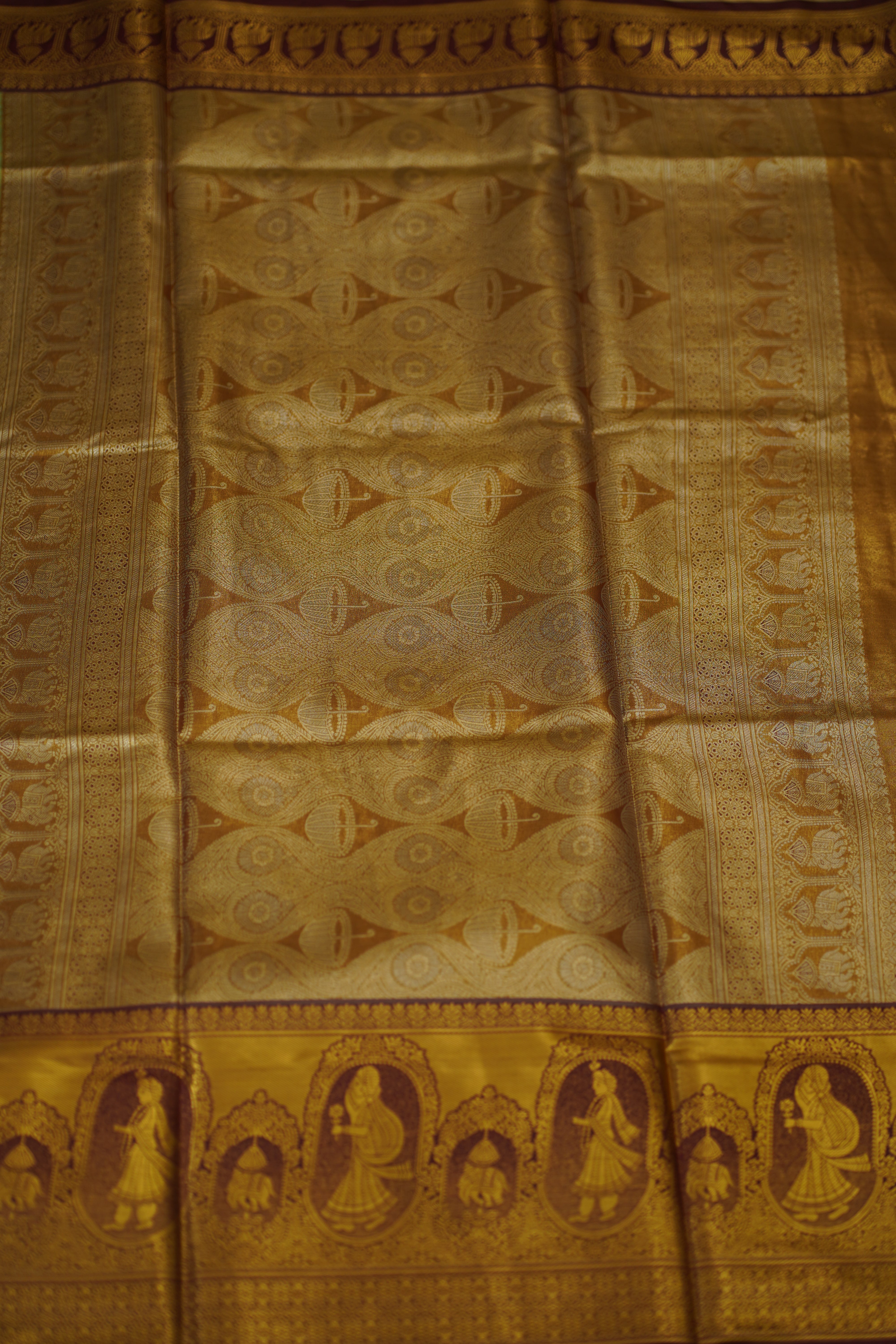 Decorative fabric with intricate patterns in gold and brown