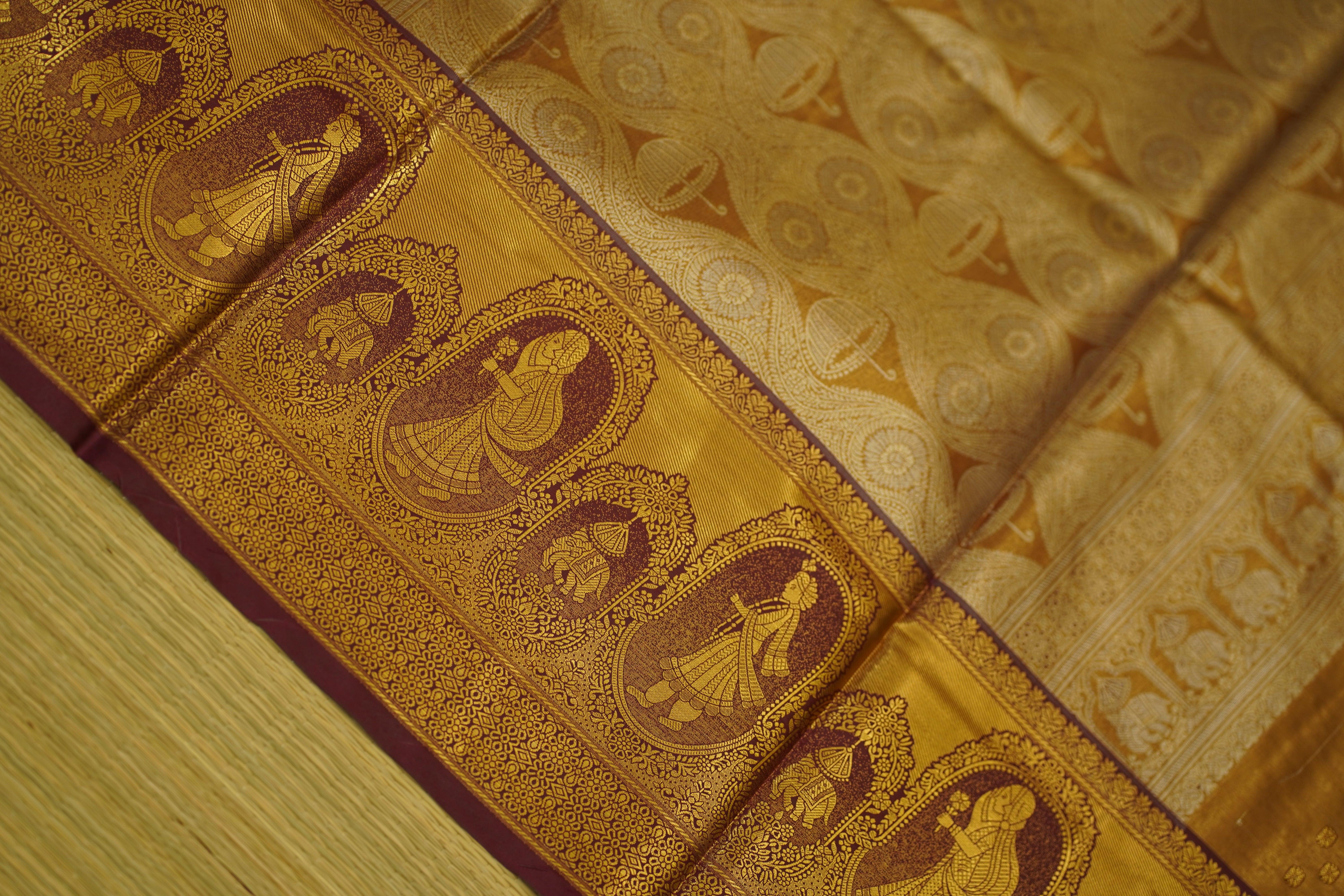 Close-up of a gold fabric with intricate patterns and designs.
