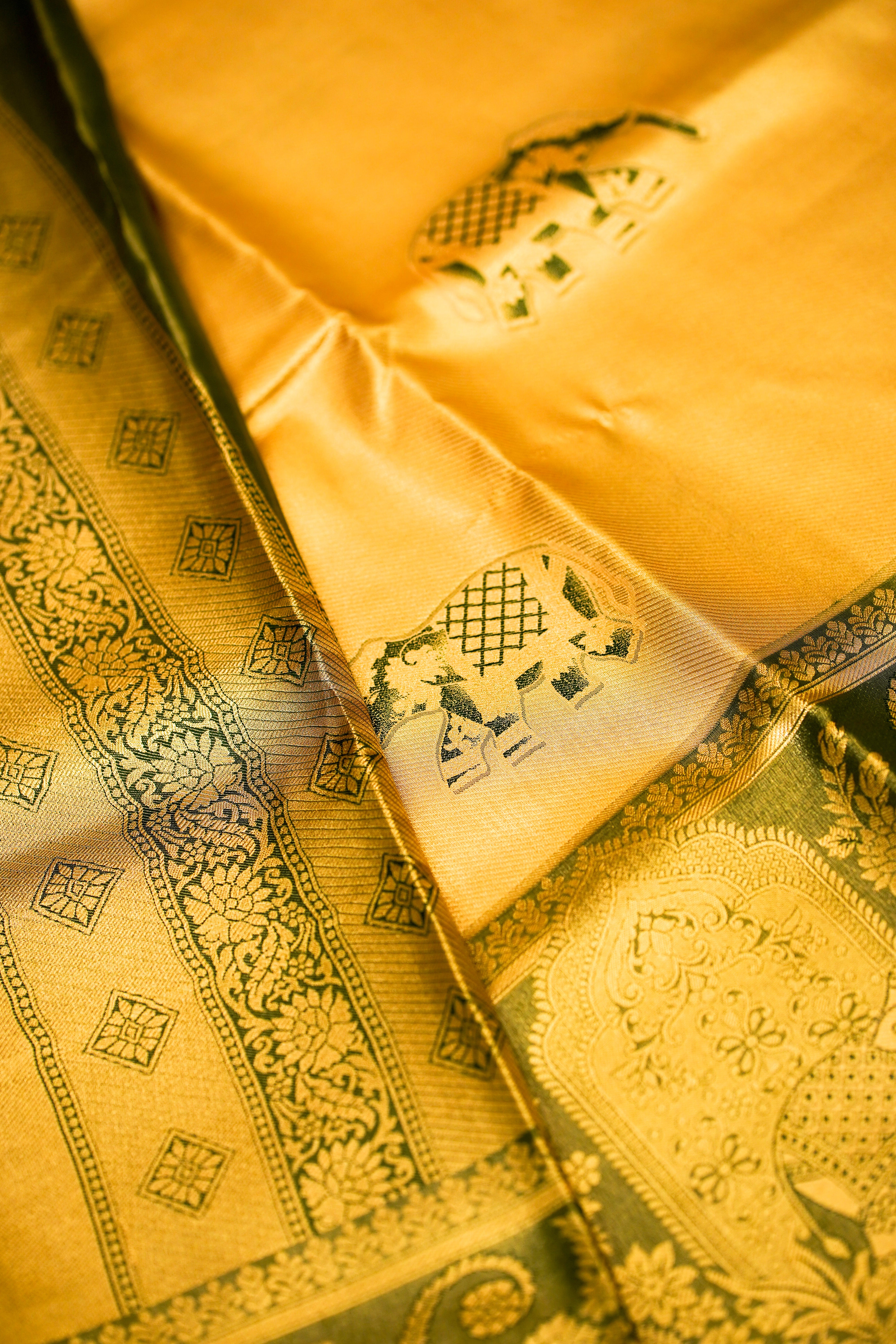 Close-up of a yellow fabric with intricate patterns and designs.