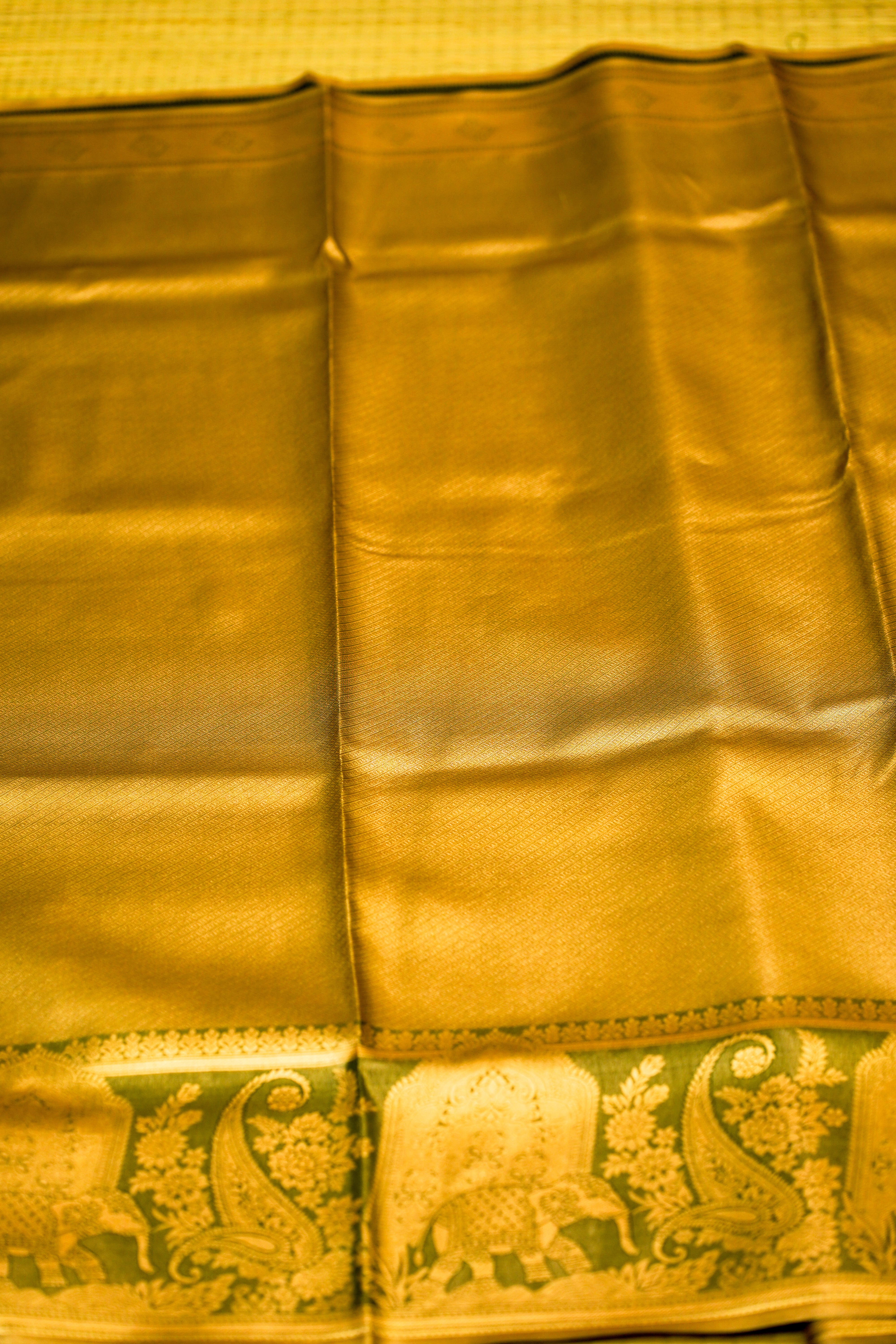 Gold fabric with elephant and paisley patterns