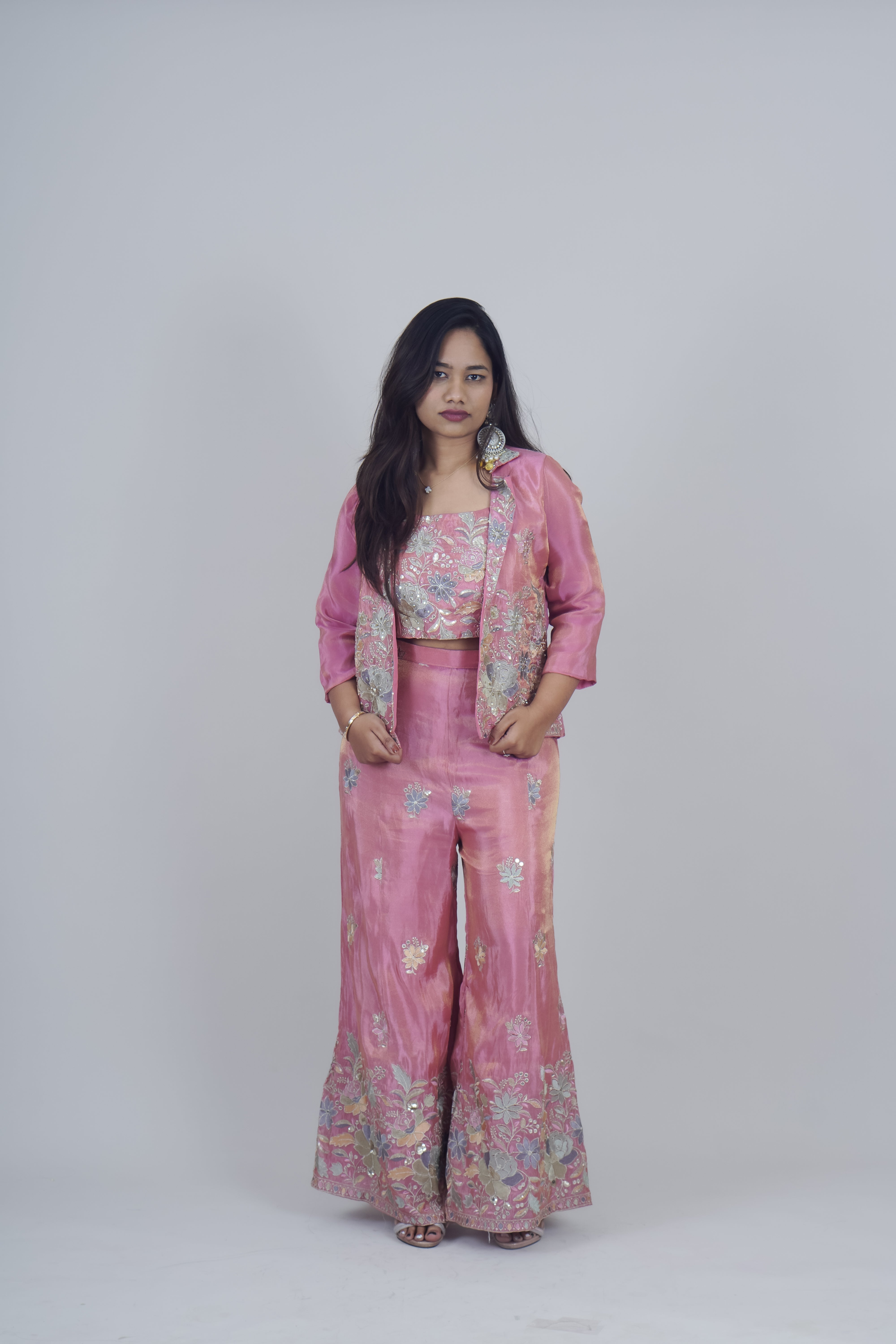 Woman wearing a pink floral outfit on a white background