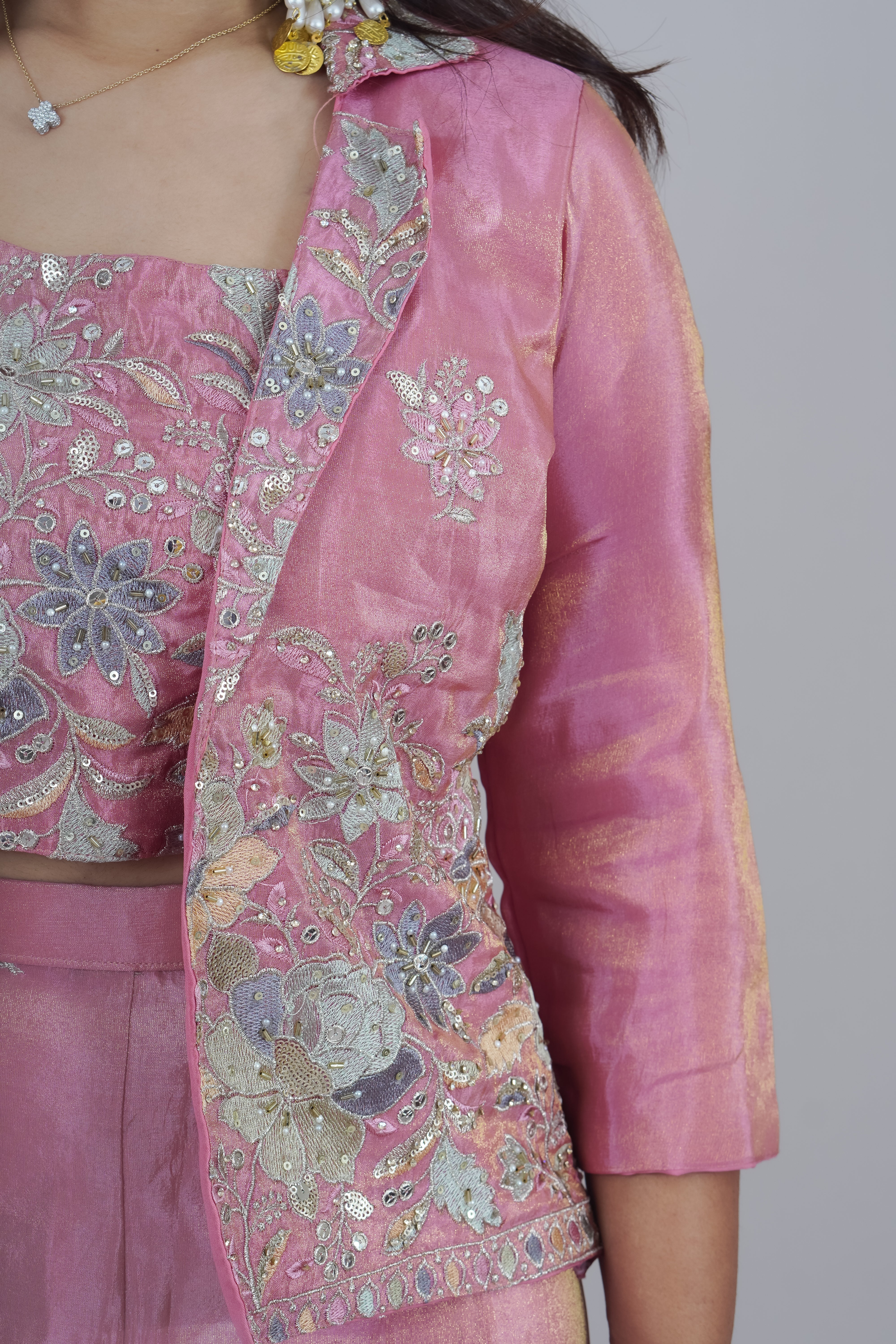 Pink traditional outfit with floral patterns on a plain background