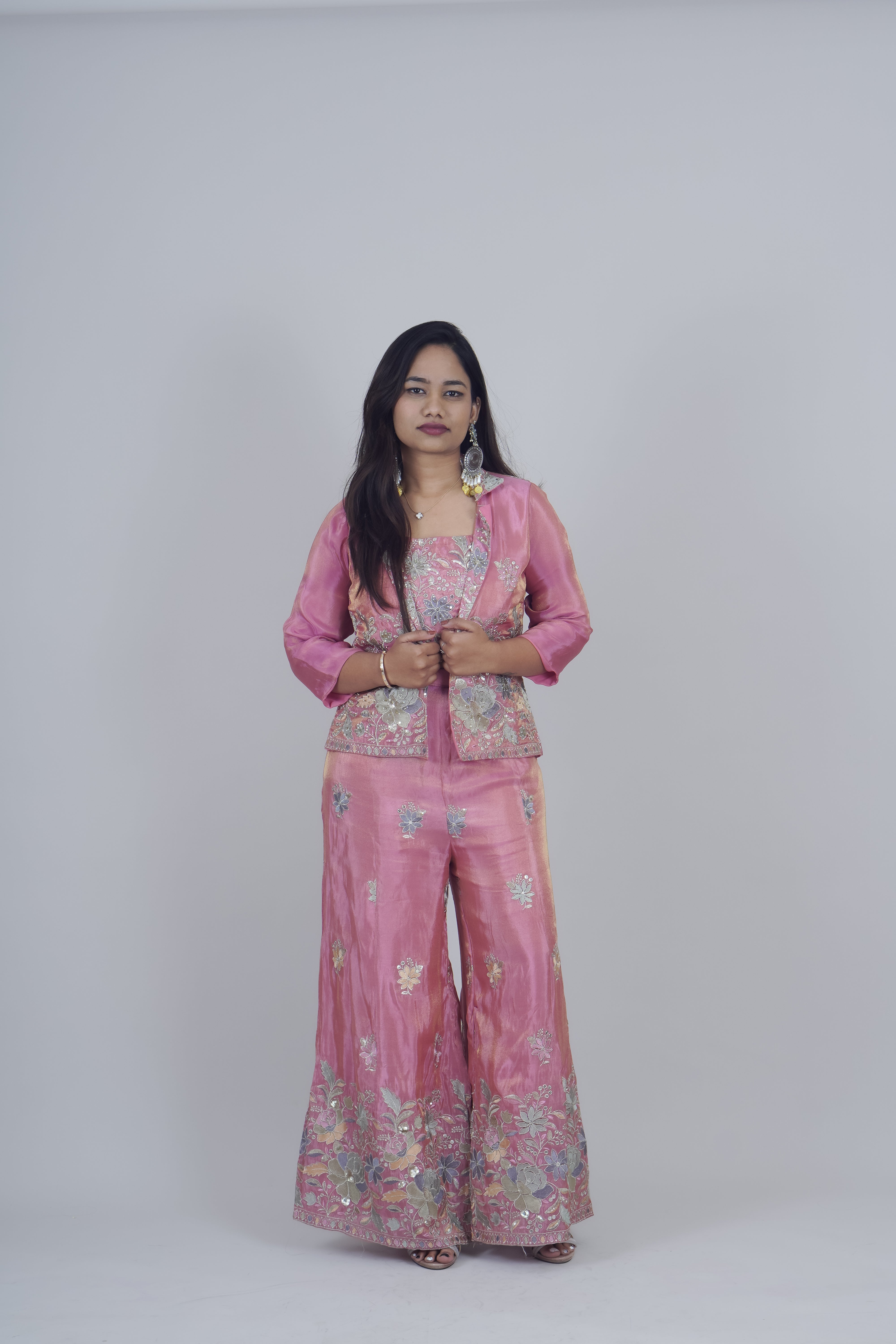 Woman wearing a pink traditional outfit with a floral pattern on a white background