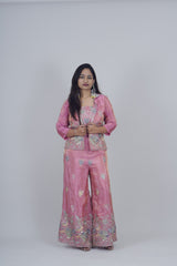 Woman wearing a pink traditional outfit with a floral pattern on a white background
