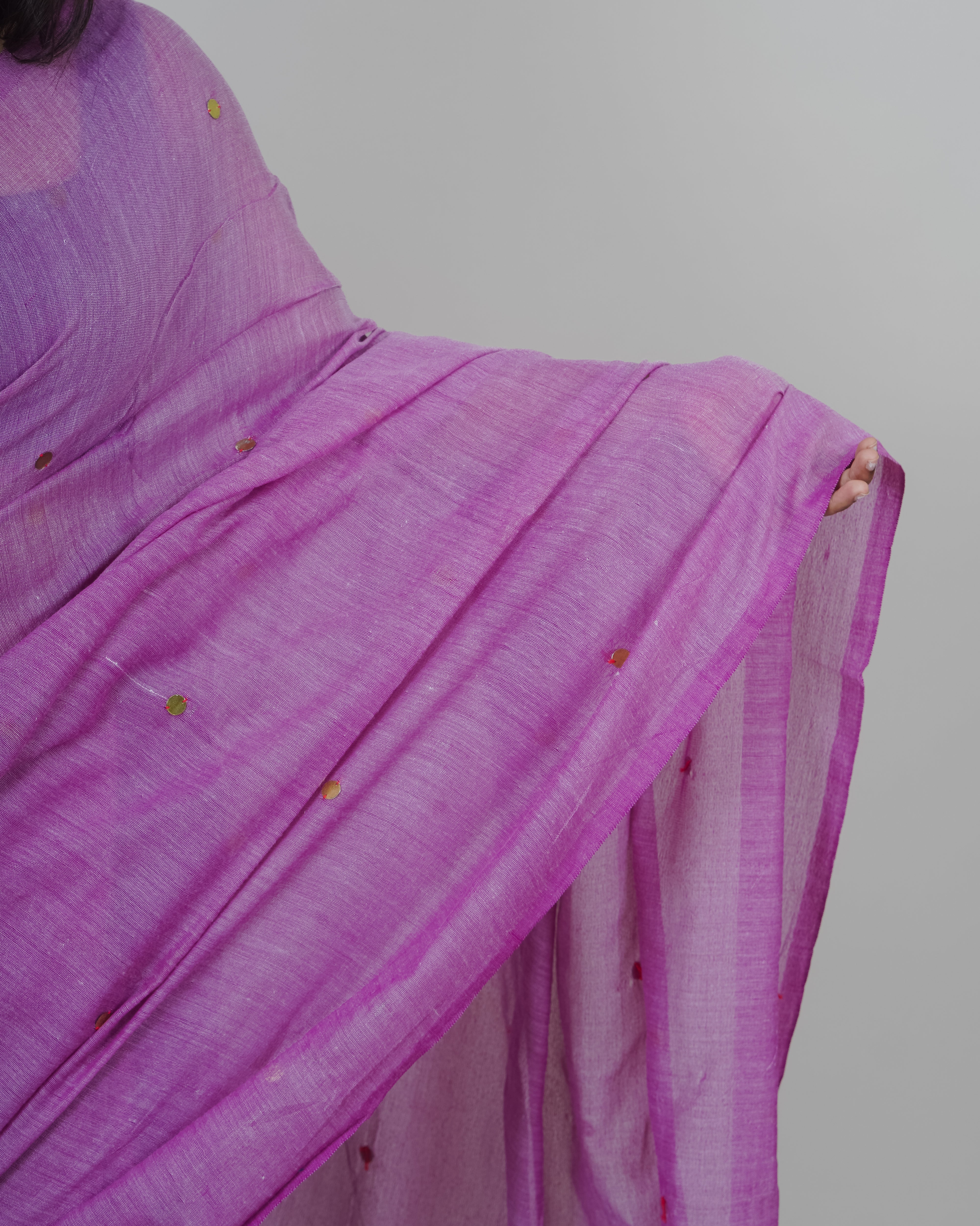Purple saree with gold accents on a plain background