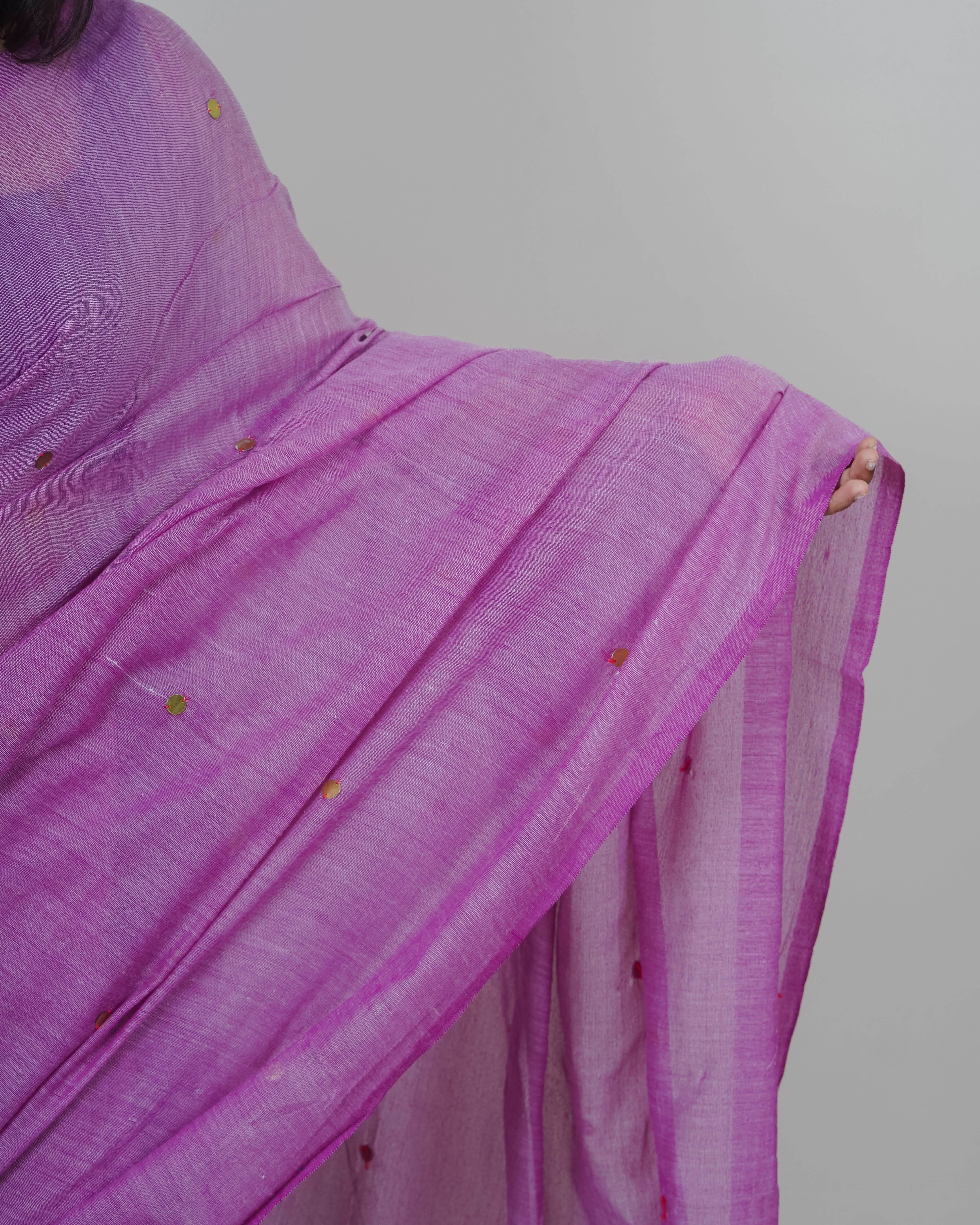 Purple saree with gold accents on a plain background