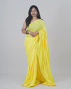 Woman wearing a yellow saree on a gray background