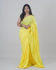 Woman wearing a yellow saree on a gray background