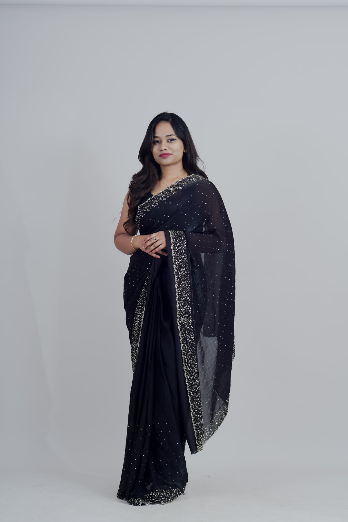 Woman wearing a black saree with gold border on a white background www.laaki.co