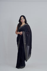 Woman wearing a black saree with gold border on a white background www.laaki.co