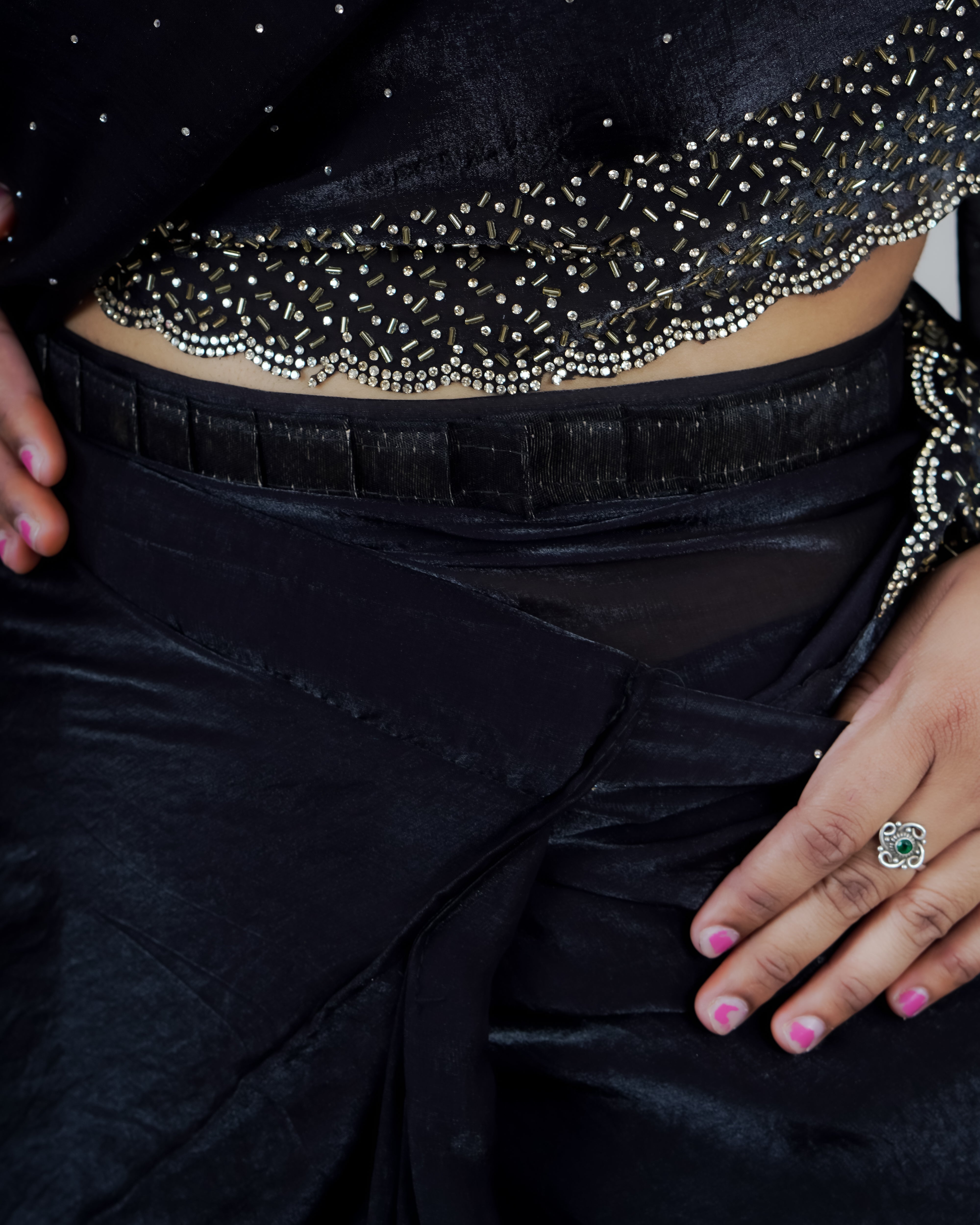 Black saree with decorative border and a ring on a hand www.laaki.co