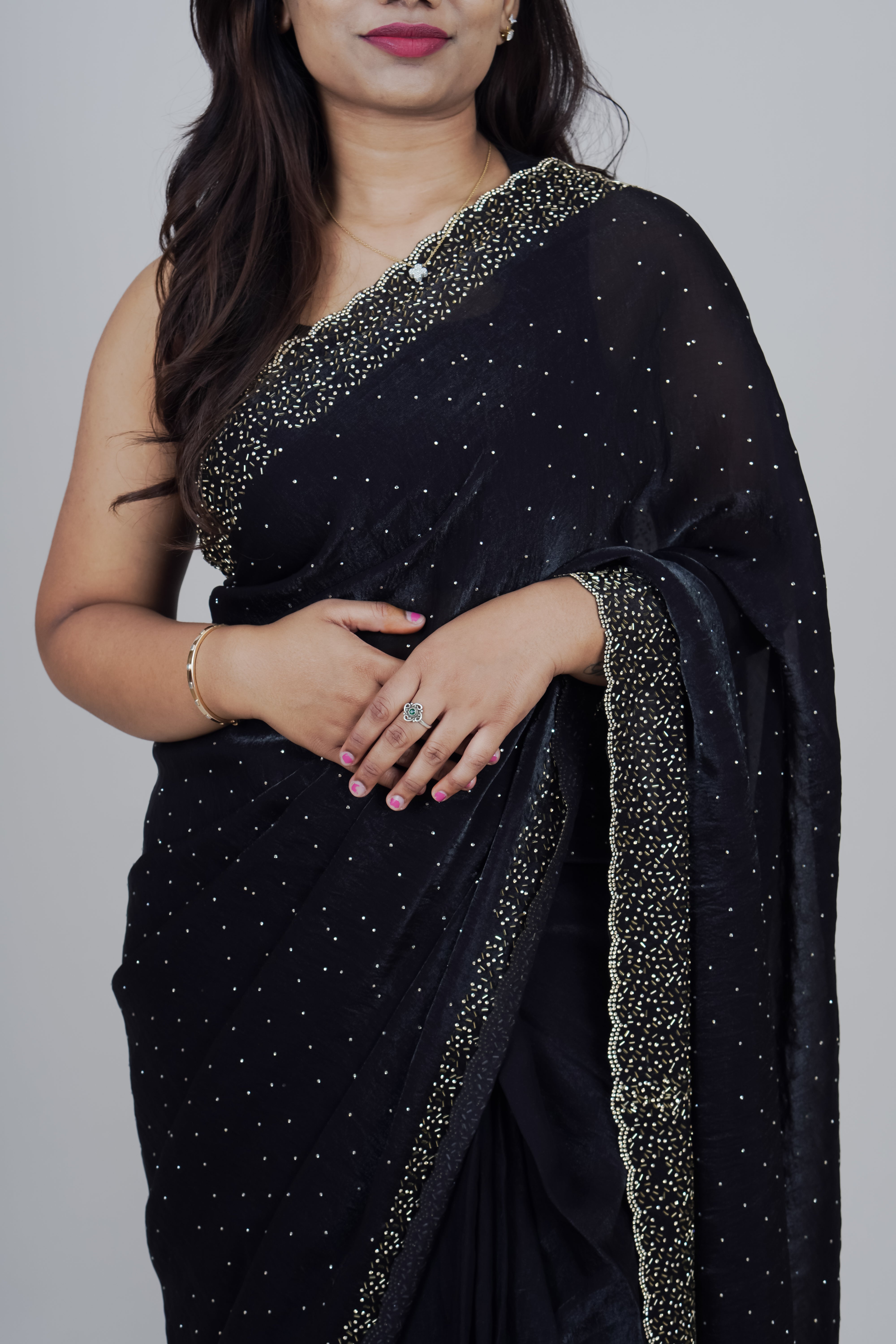 Woman wearing a black saree with silver border on a gray background www.laaki.co