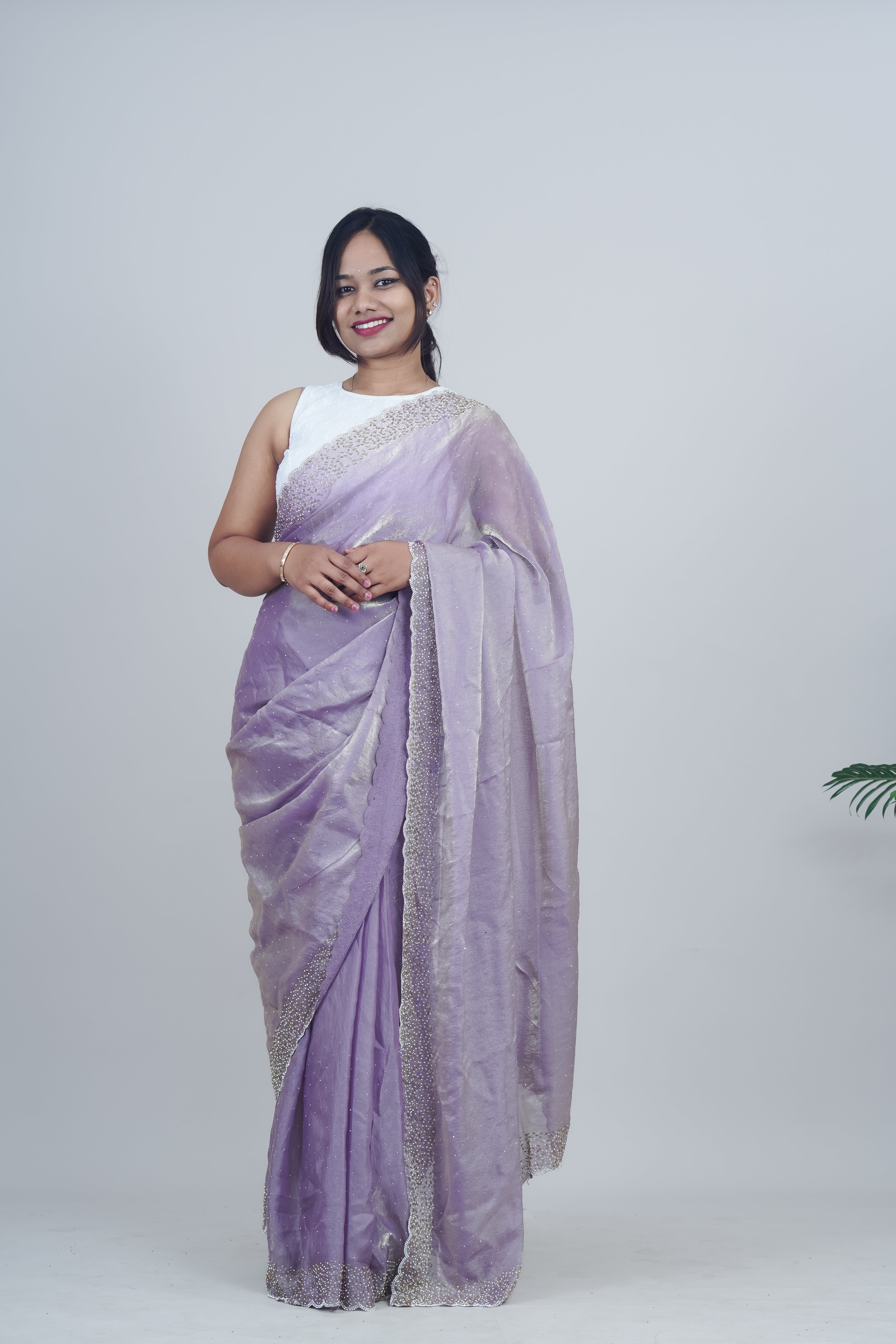 Woman wearing a lavender saree with a white blouse against a plain background www.laaki.co