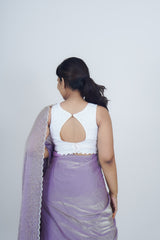 Woman wearing a white top and purple saree with a white background www.laaki.co