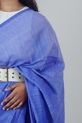 Blue fabric draped over a person with a white belt on a gray background