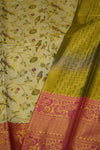 Close-up of a traditional saree with floral patterns and a pink border.
