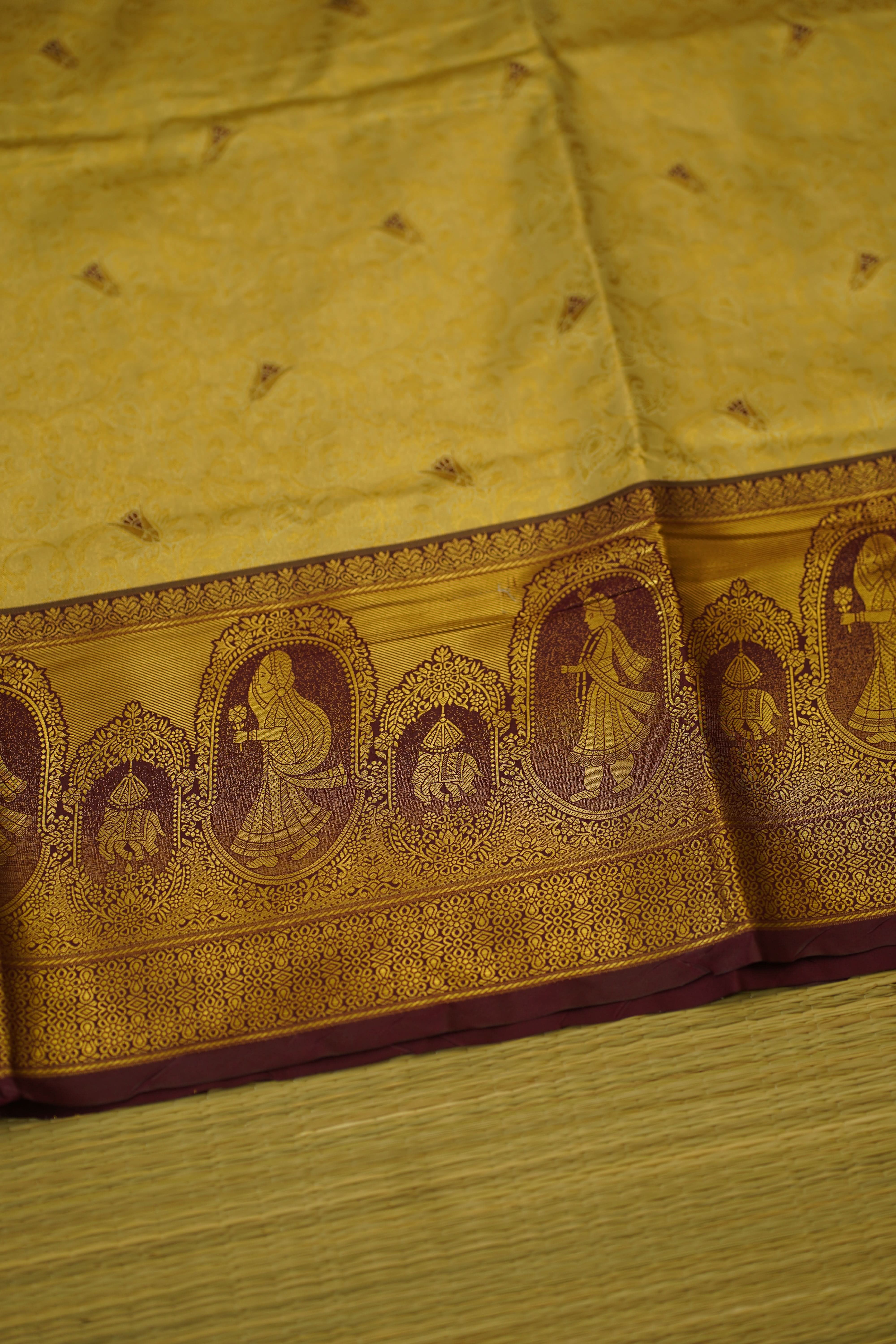 Close-up of a decorative fabric with intricate patterns on a yellow  DHARMAVARAMbackground
