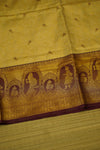 Close-up of a decorative fabric with intricate patterns on a yellow  DHARMAVARAMbackground
