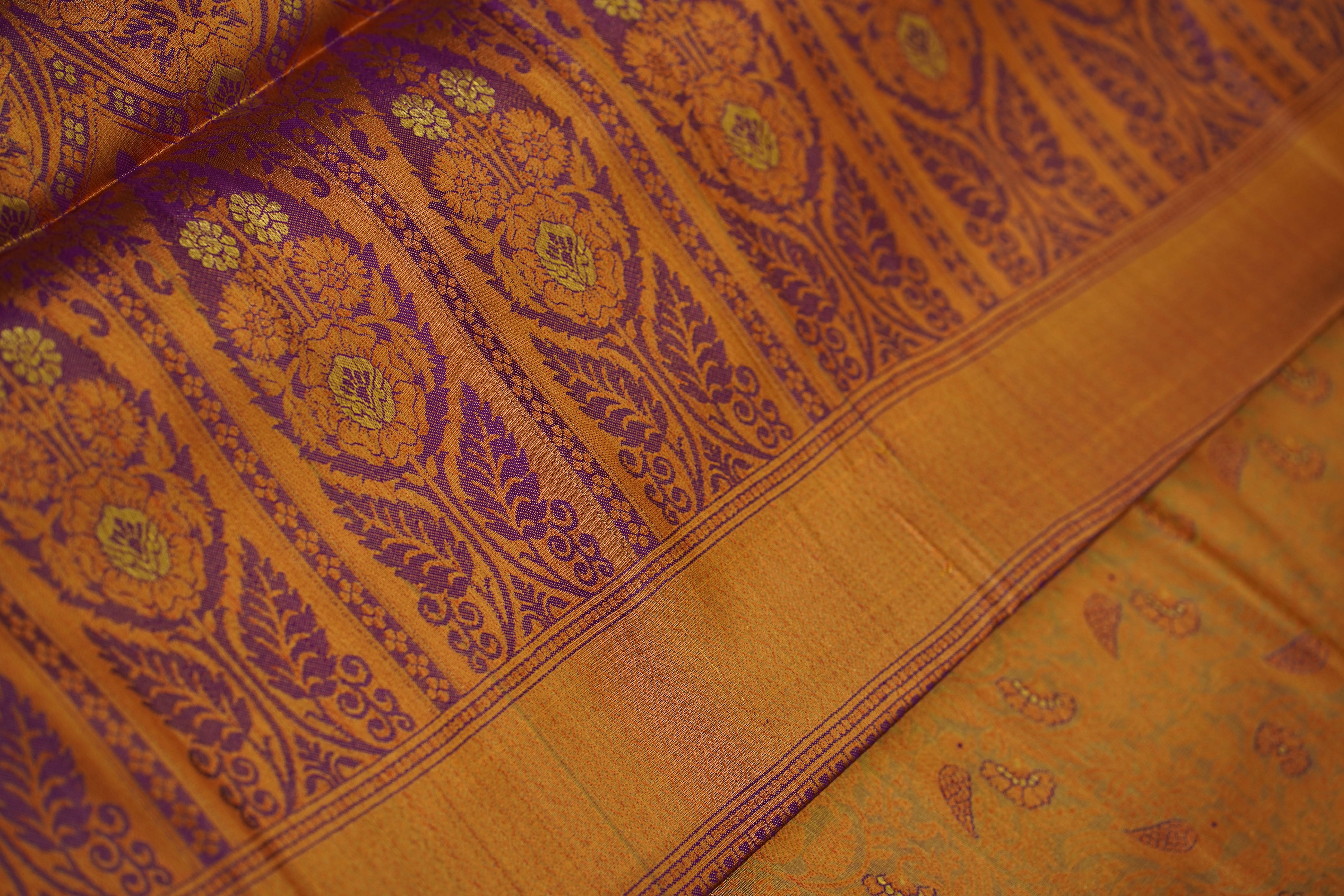 Close-up of a yellow fabric with intricate purple and green patterns