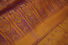 Close-up of a yellow fabric with intricate purple and green patterns