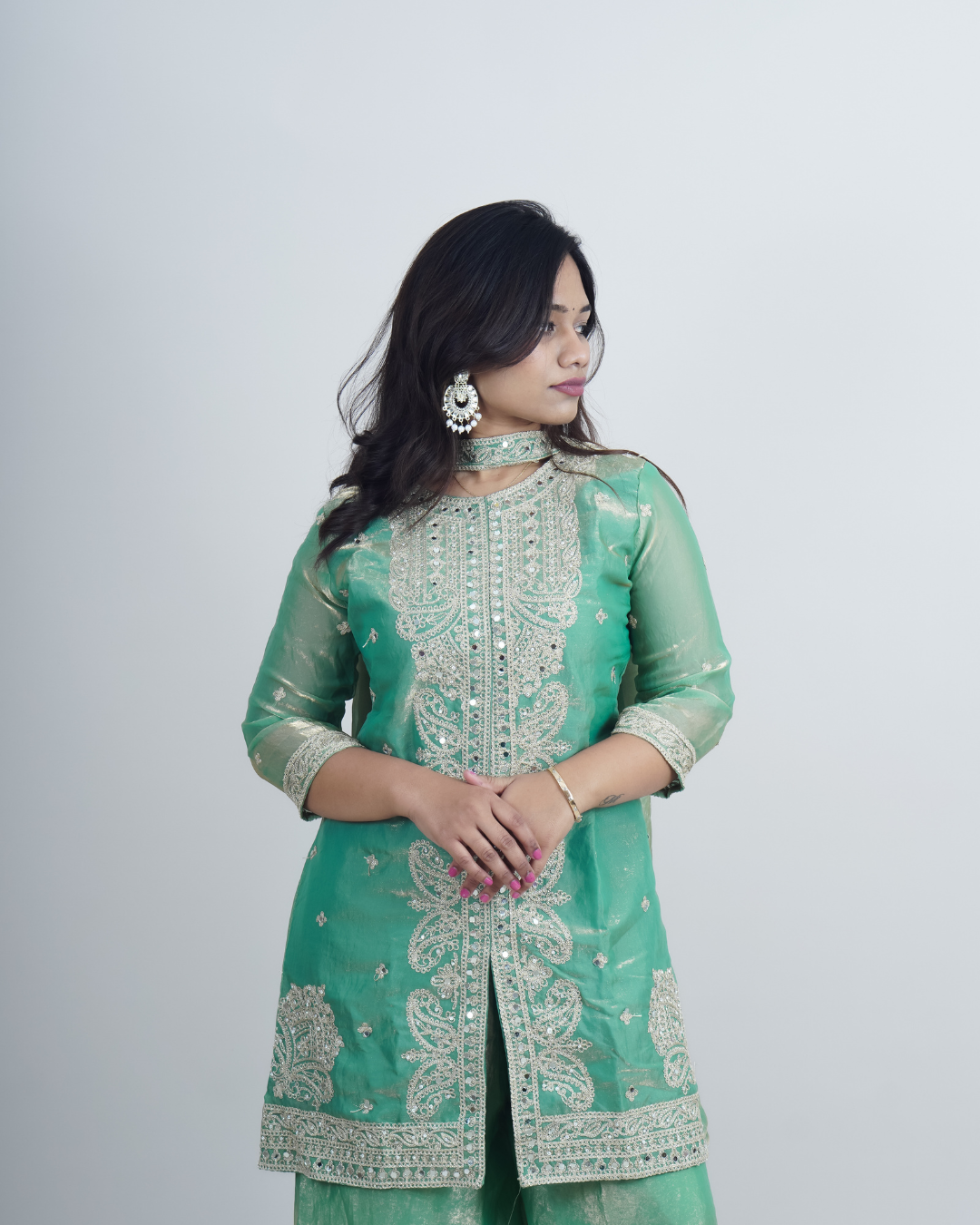 Woman wearing a green embroidered traditional outfit on a white background www.laaki.co