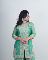 Woman wearing a green embroidered traditional outfit on a white background www.laaki.co