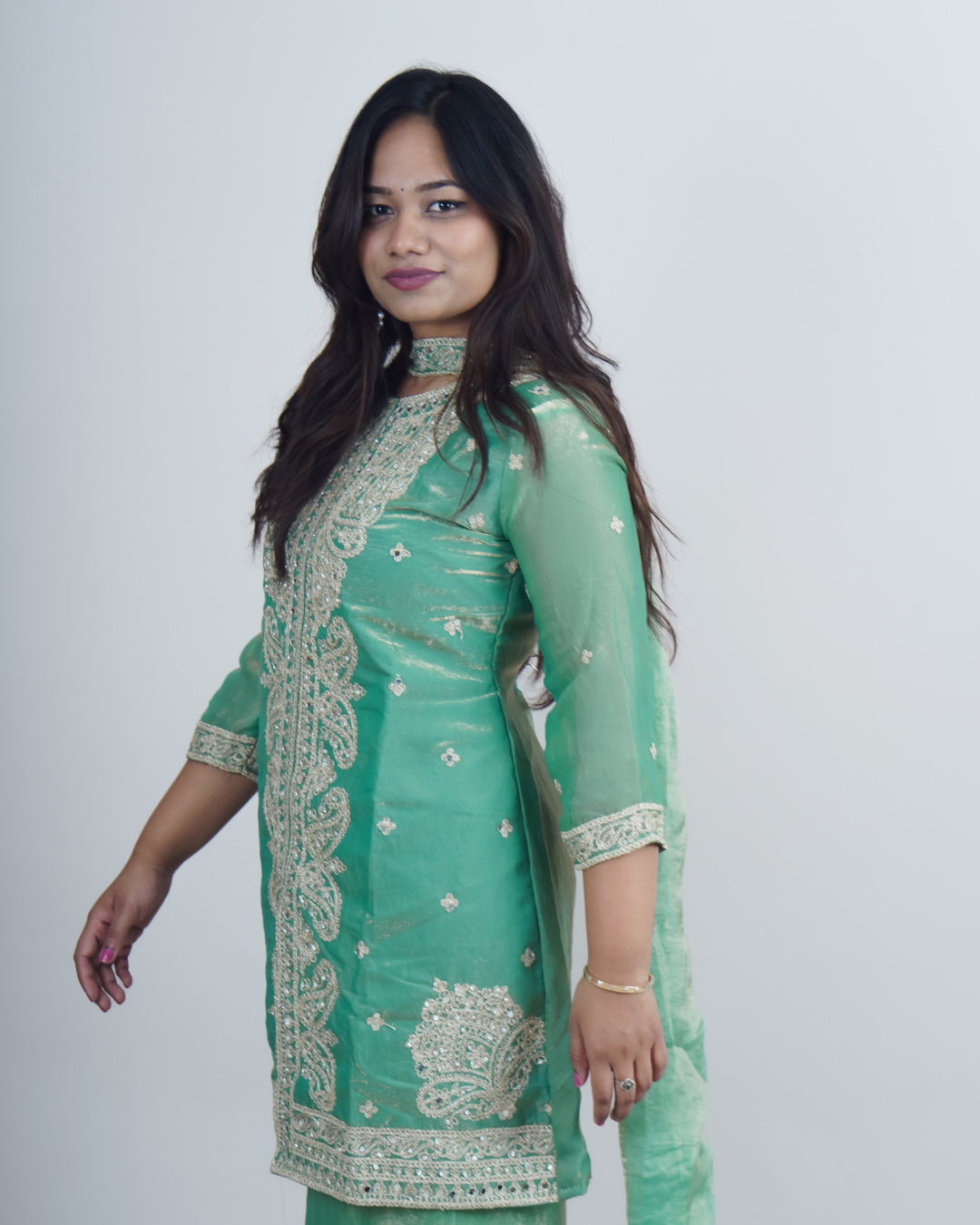 Woman wearing a green embroidered traditional outfit on a white background www.laaki.co