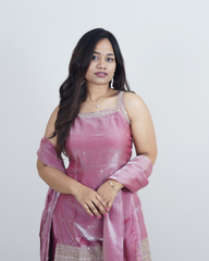 Woman wearing a pink traditional outfit with a plain background