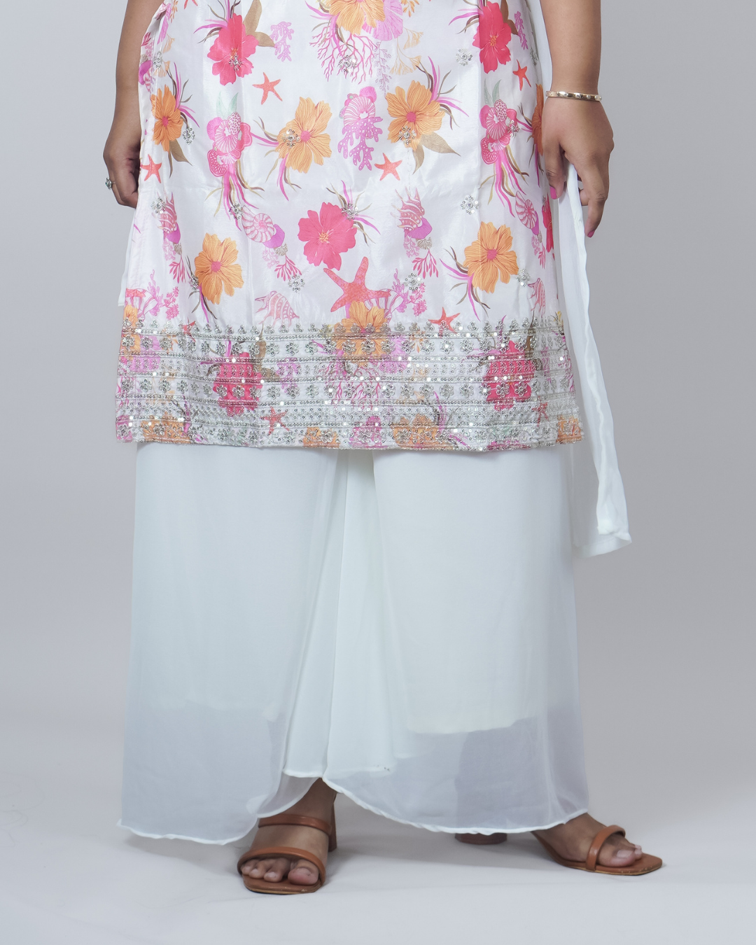 Person wearing a floral dress with a white dupatta on a plain background www.laaki.co