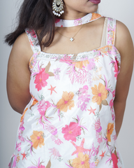 Woman wearing a floral dress with pink and orange flowers on a white background www.laaki.co