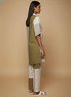 laaki Woman wearing a traditional outfit with a green dupatta and striped pants on a beige background