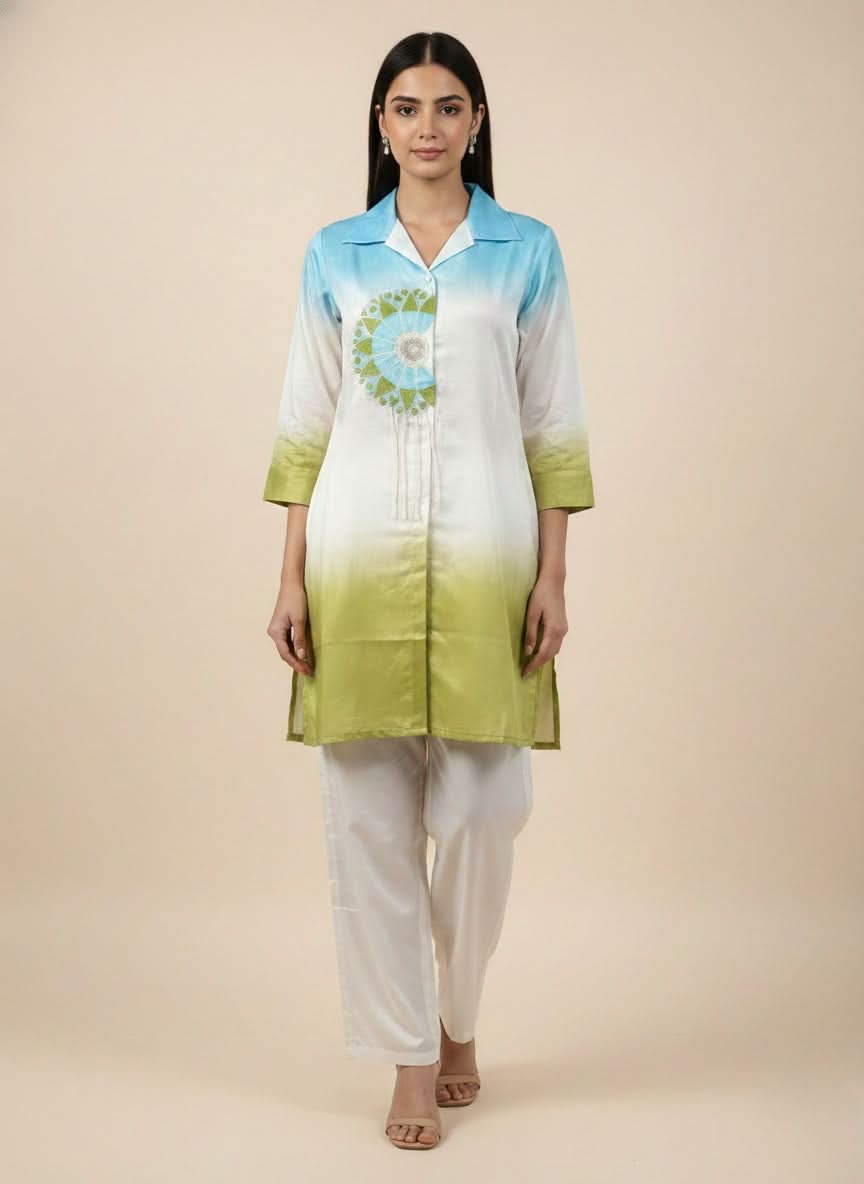 Woman wearing a green and blue gradient kurta with white pants on a beige background. www.laaki.co