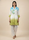 Woman wearing a green and blue gradient kurta with white pants on a beige background. www.laaki.co