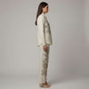 Woman wearing a beige embroidered outfit on a plain background. www.laaki.co www.laaki.co