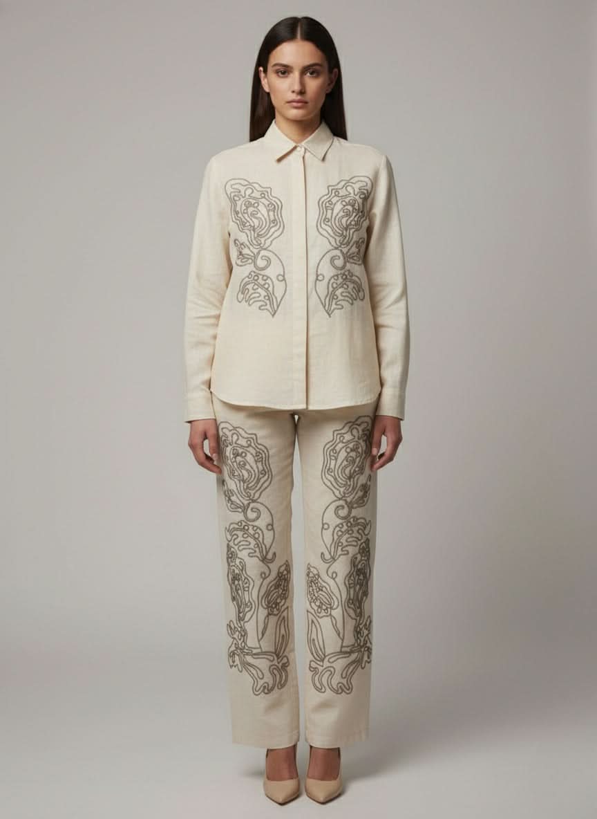 Woman wearing a cream-colored embroidered outfit on a plain  www.laaki.co background www.laaki.co