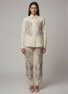 Woman wearing a cream-colored embroidered outfit on a plain  www.laaki.co background www.laaki.co