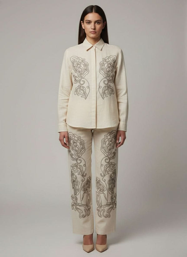 Woman wearing a cream-colored embroidered outfit on a plain  www.laaki.co background www.laaki.co