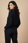 Woman wearing a black outfit against a beige background www.laaki.co