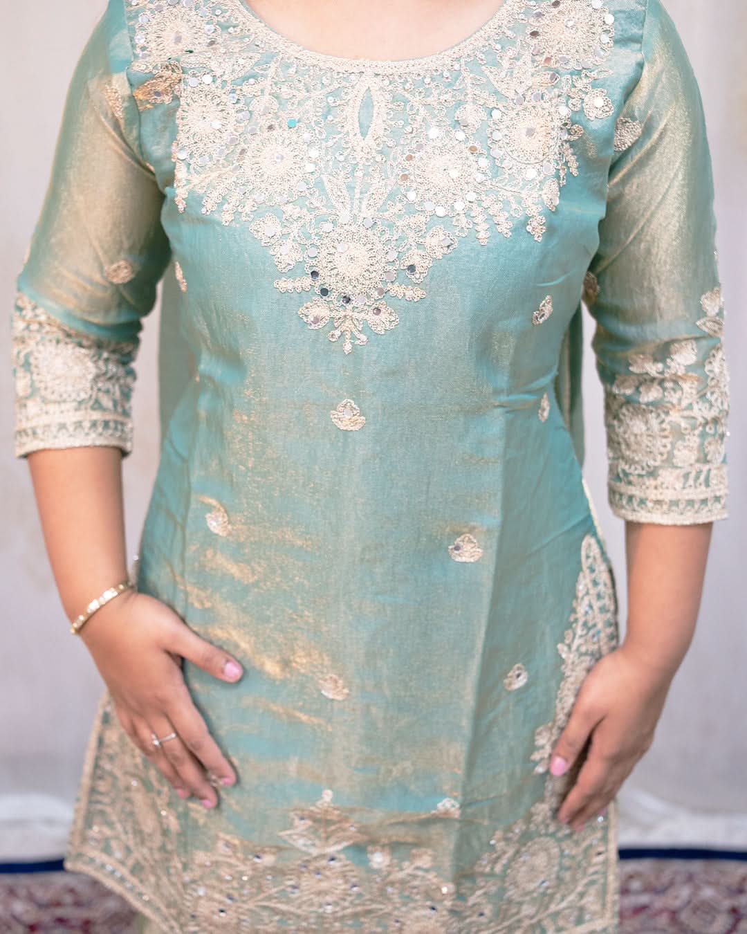 Light blue embroidered dress with intricate patterns on a plain background. laaki