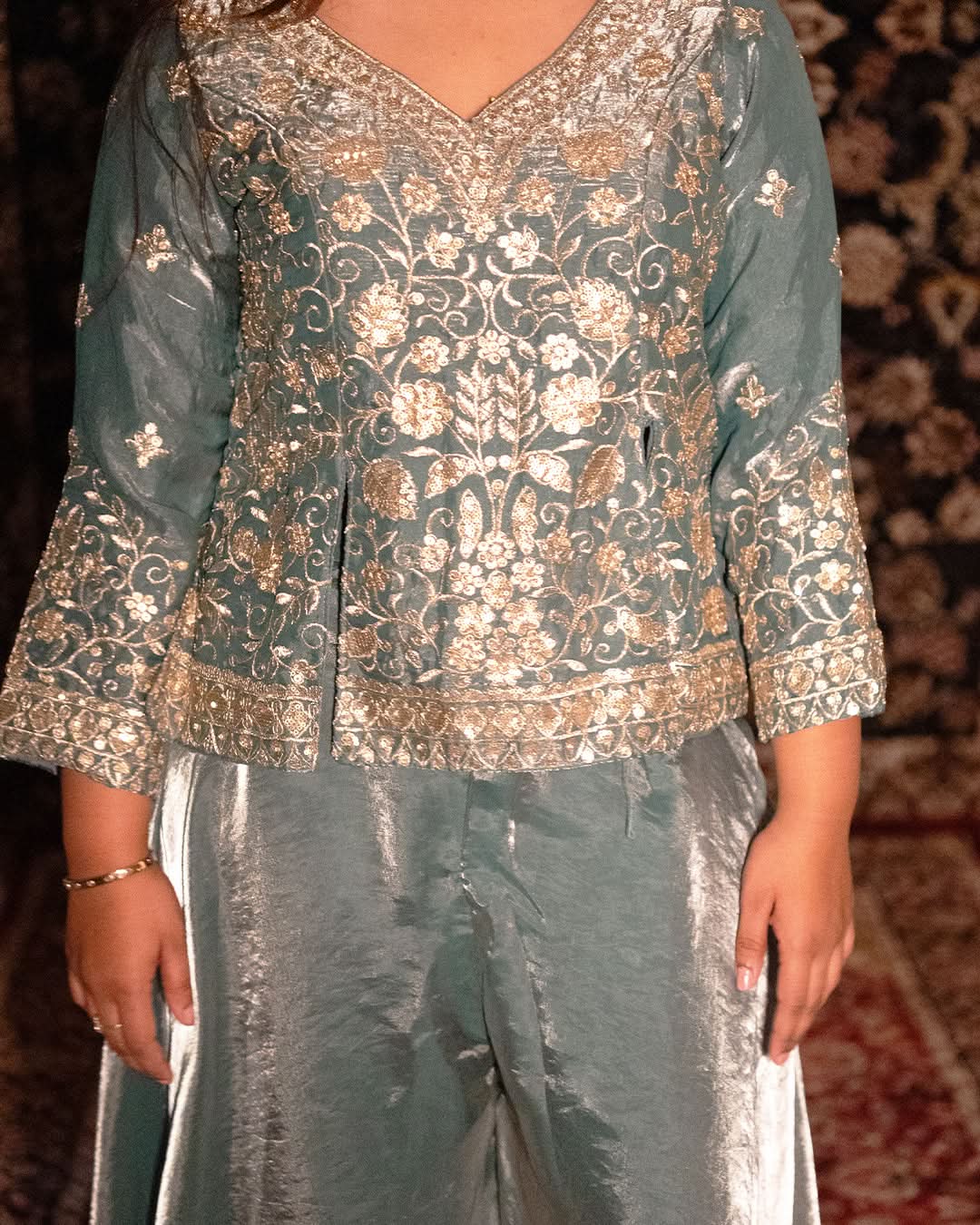 Traditional embroidered top and pants on a patterned carpet background laaki